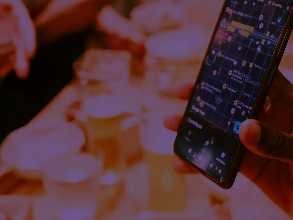 Someone checking a map on their phone in a bar at night