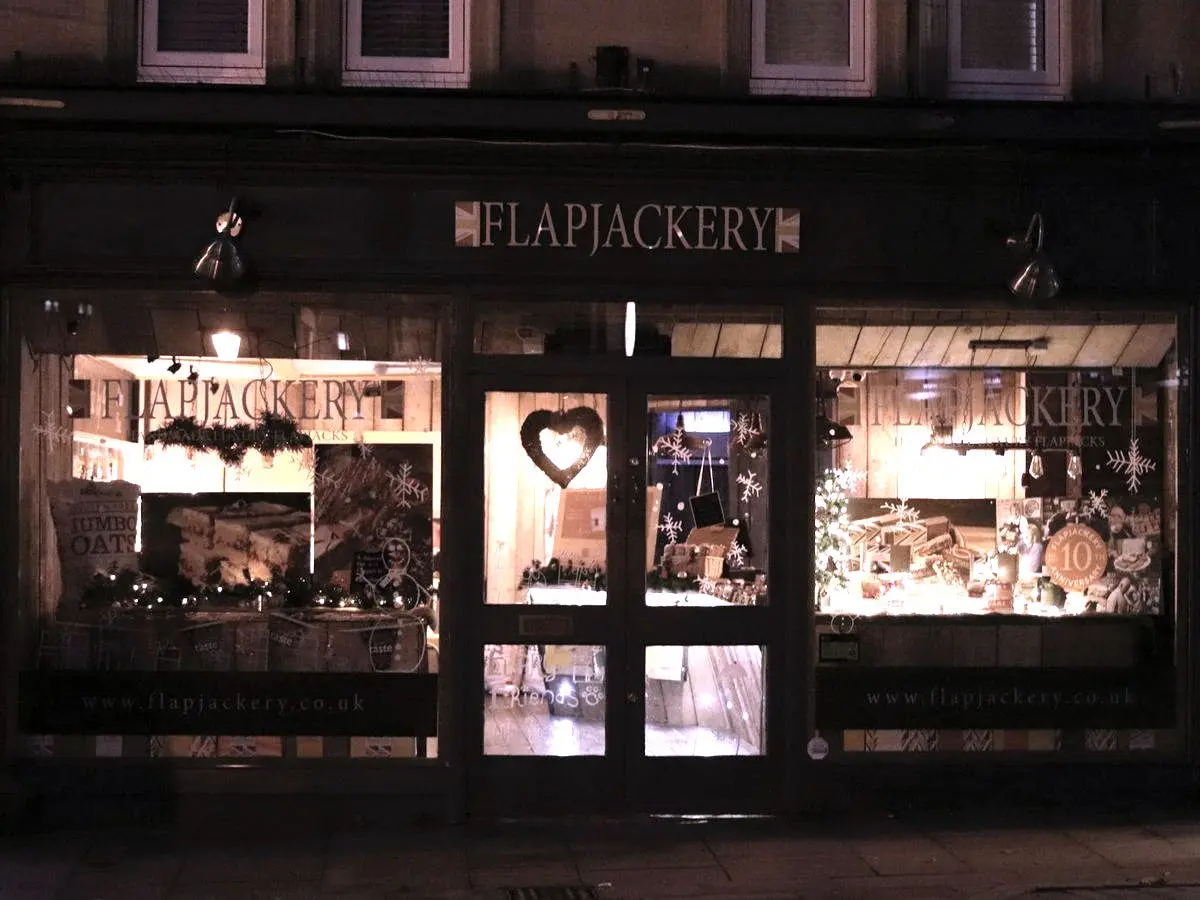 A small shop lit from inside on a dark street
