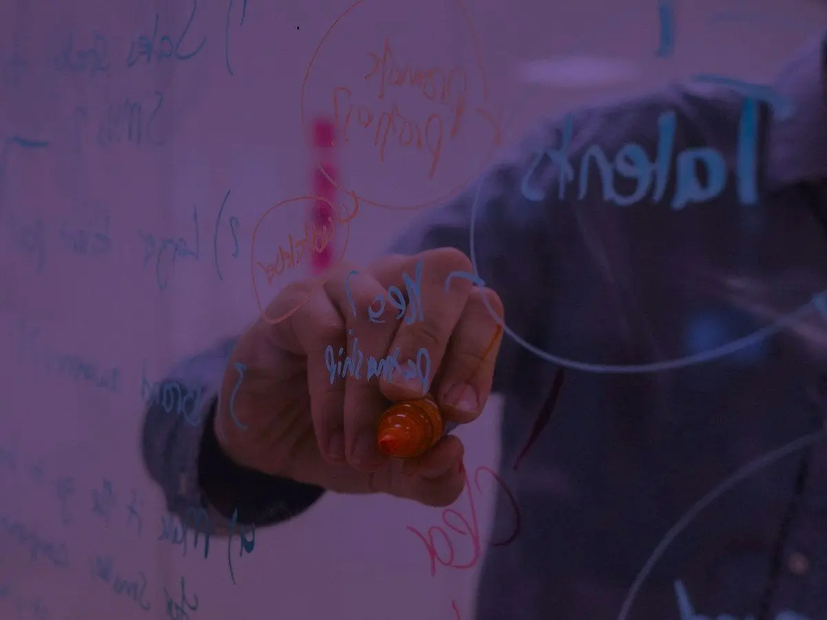 A strategist mapping out a keyword plan on a glass wall